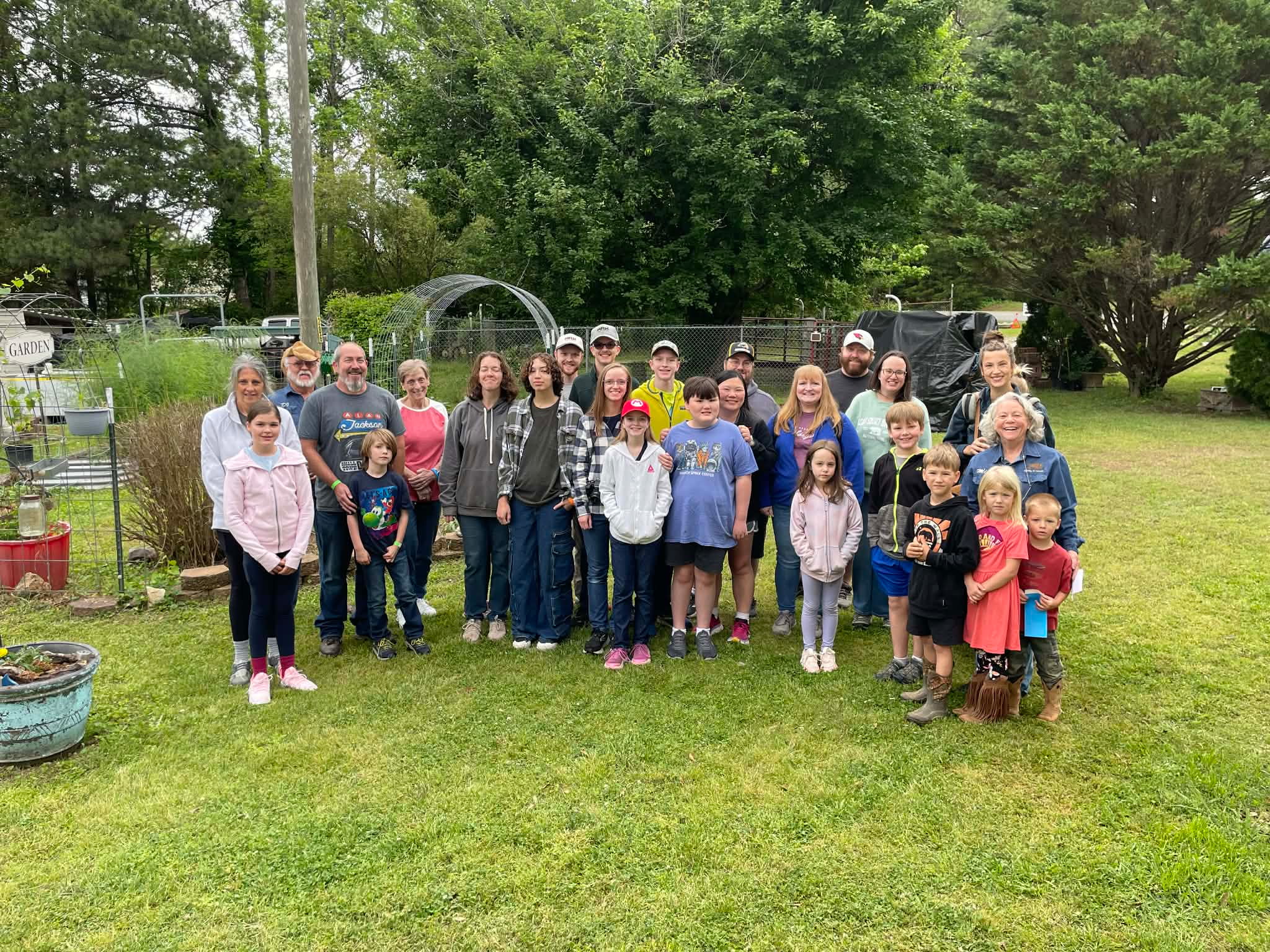 A smaller group of families and kids posed together in the garden during a spring visit
